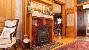 Een klassiek interieur met een bakstenen open haard, houten meubels en een kamerbreed tapijt met dessin.