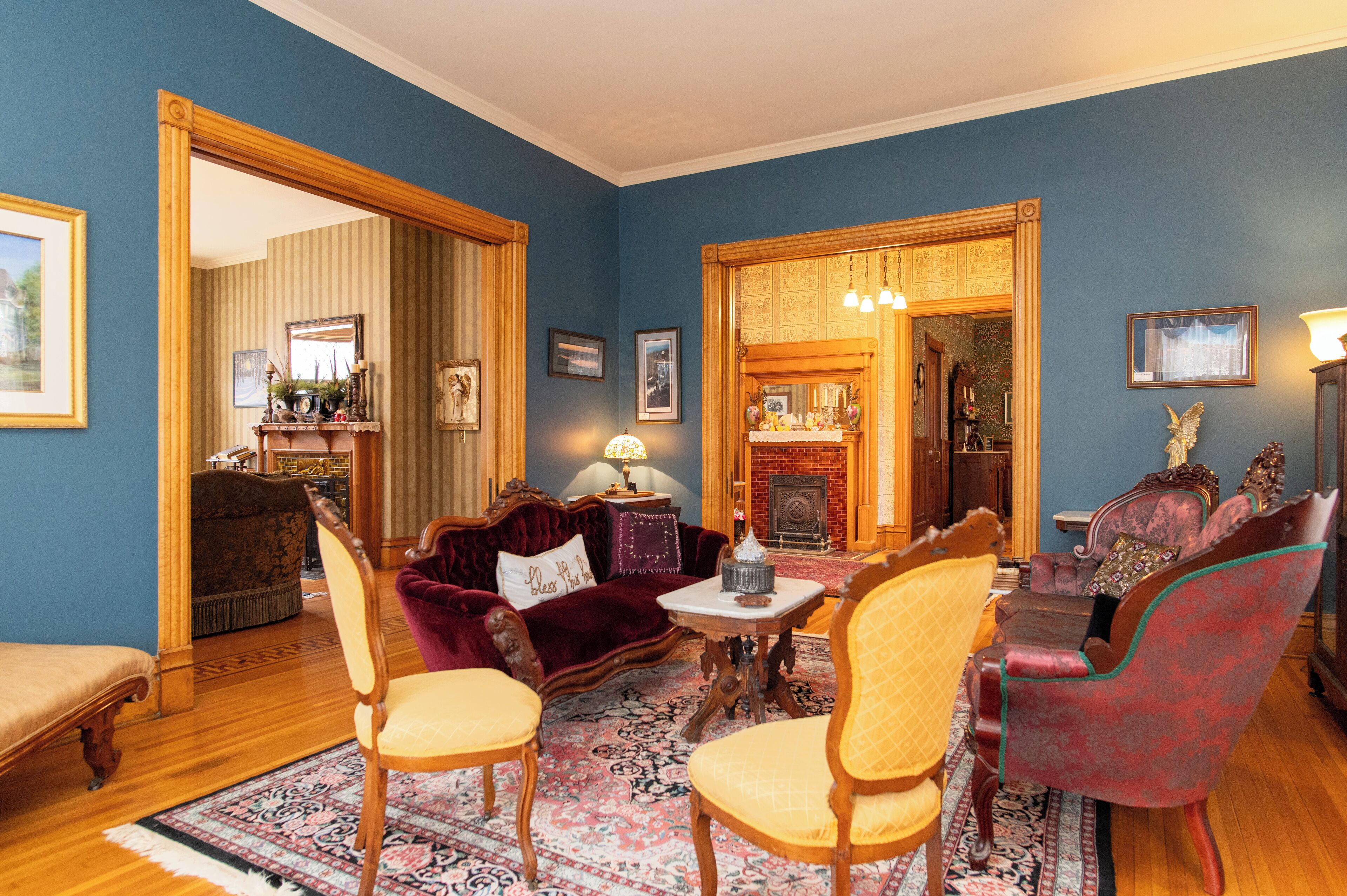 A traditional living room with a fireplace, wooden furniture, and a patterned rug.