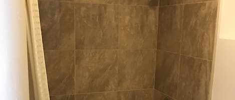 A bathroom with a bathtub, toilet, and shower curtain.