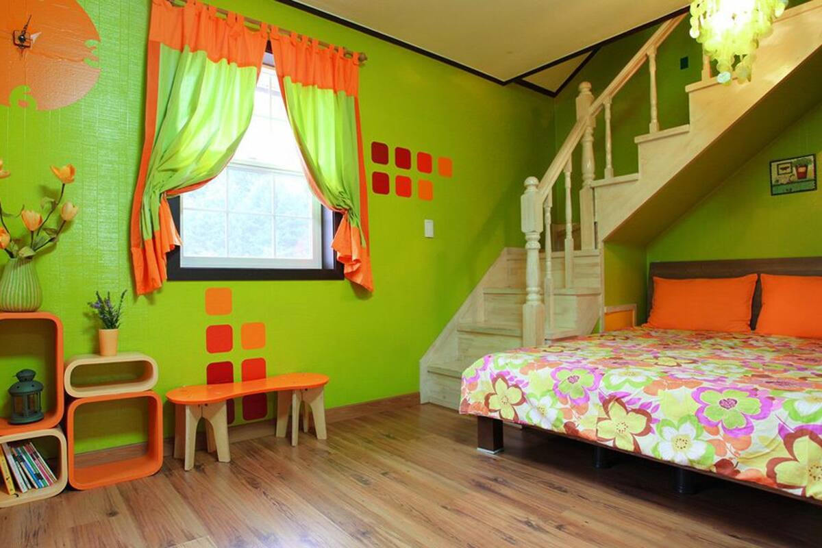 Un dormitorio con cama, escritorio, silla, ventana con cortinas, escalera y un reloj de pared.
