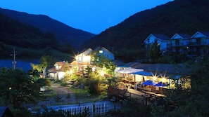 A lakeside lodge with multiple buildings, outdoor seating, and a dock. - Duo Pension (Pyeongchang)