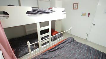 A bunk bed room with a white door and a small window.