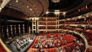 Un vaste auditorium intérieur doté de gradins, d’une scène et d’un imposant lustre.