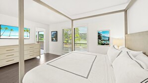 A modern bedroom with a large bed, a dresser, and a view of the outdoors through the windows. - Restoration Hardware PGA National Condo w/ 180° Golf Course Views (Palm Beach Gardens)