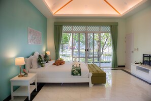 A bedroom with a bed, bedside table, green curtains, and a view of the outdoors. - Tubtim Siam River Kwai Resort (Kanchanaburi)