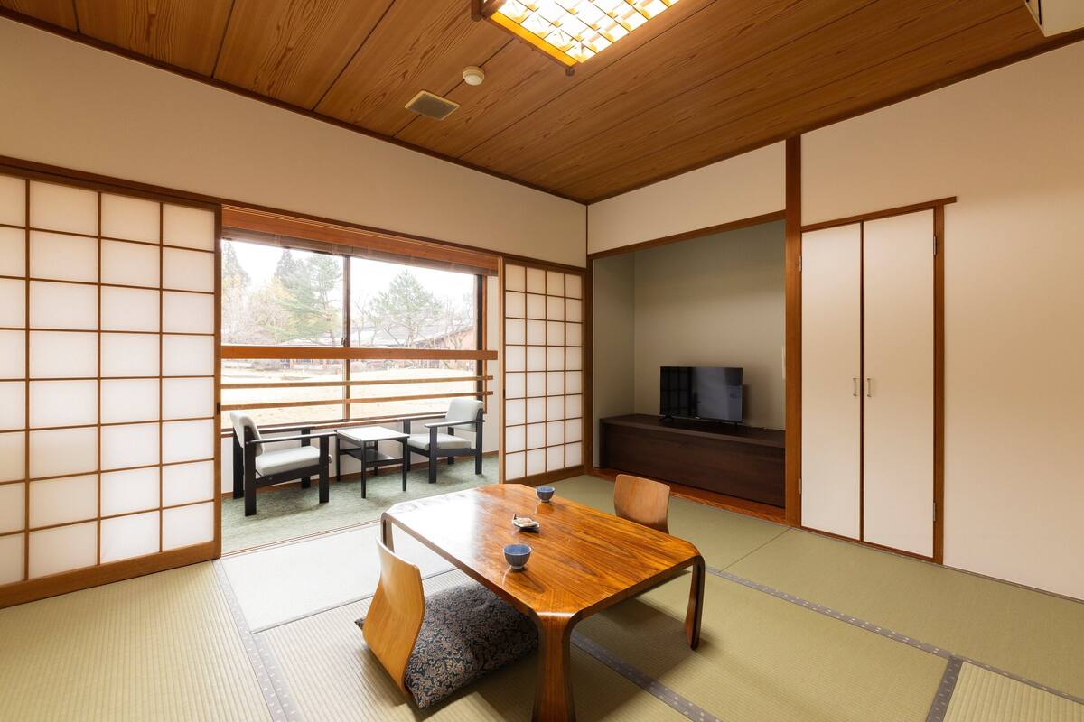 Une pièce de style japonais traditionnel, avec un sol recouvert de tatamis, une basse table en bois et des portes coulissantes en papier de riz (shoji).