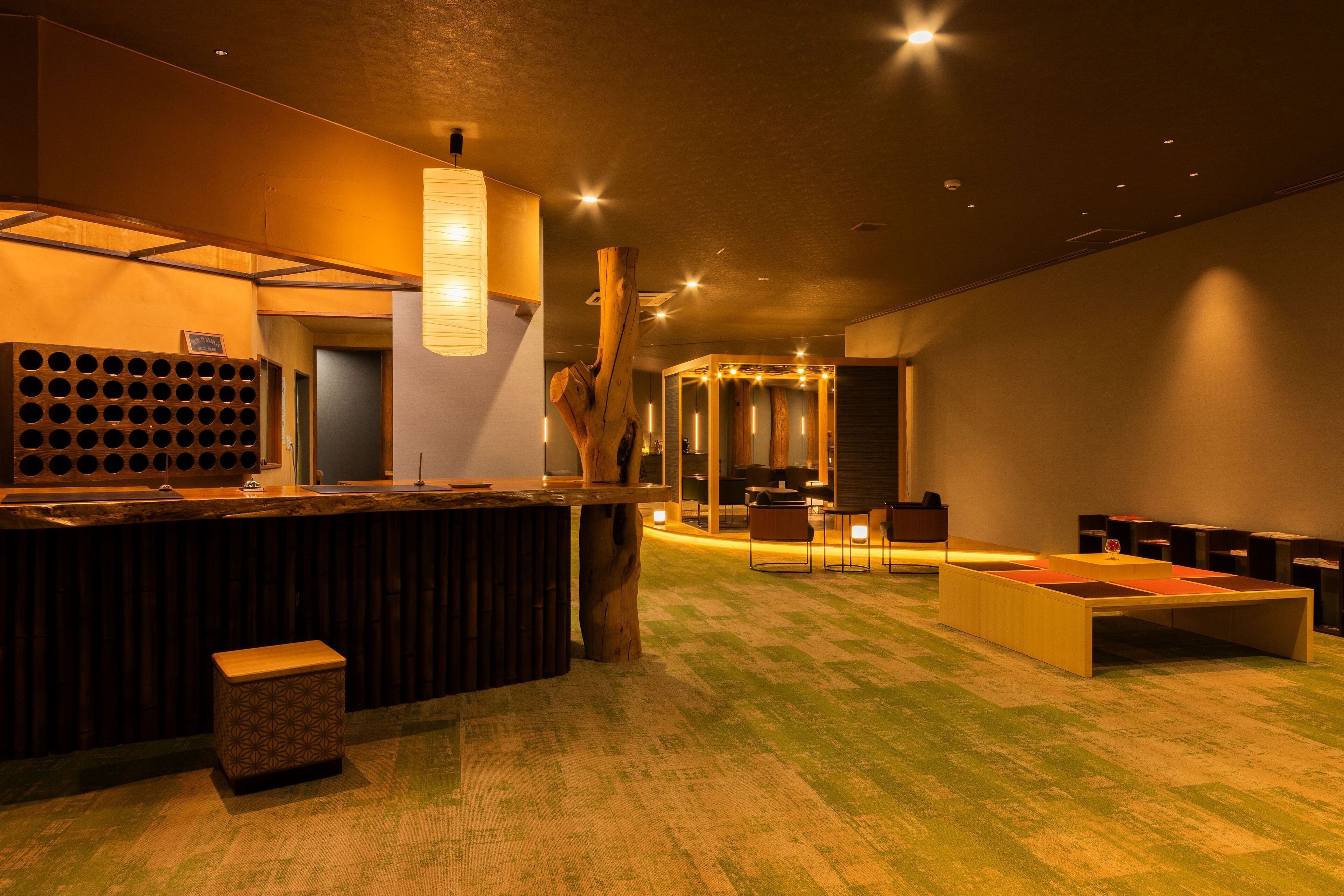 Een modern interieur met een bar, zitplaatsen en een wand van hout.