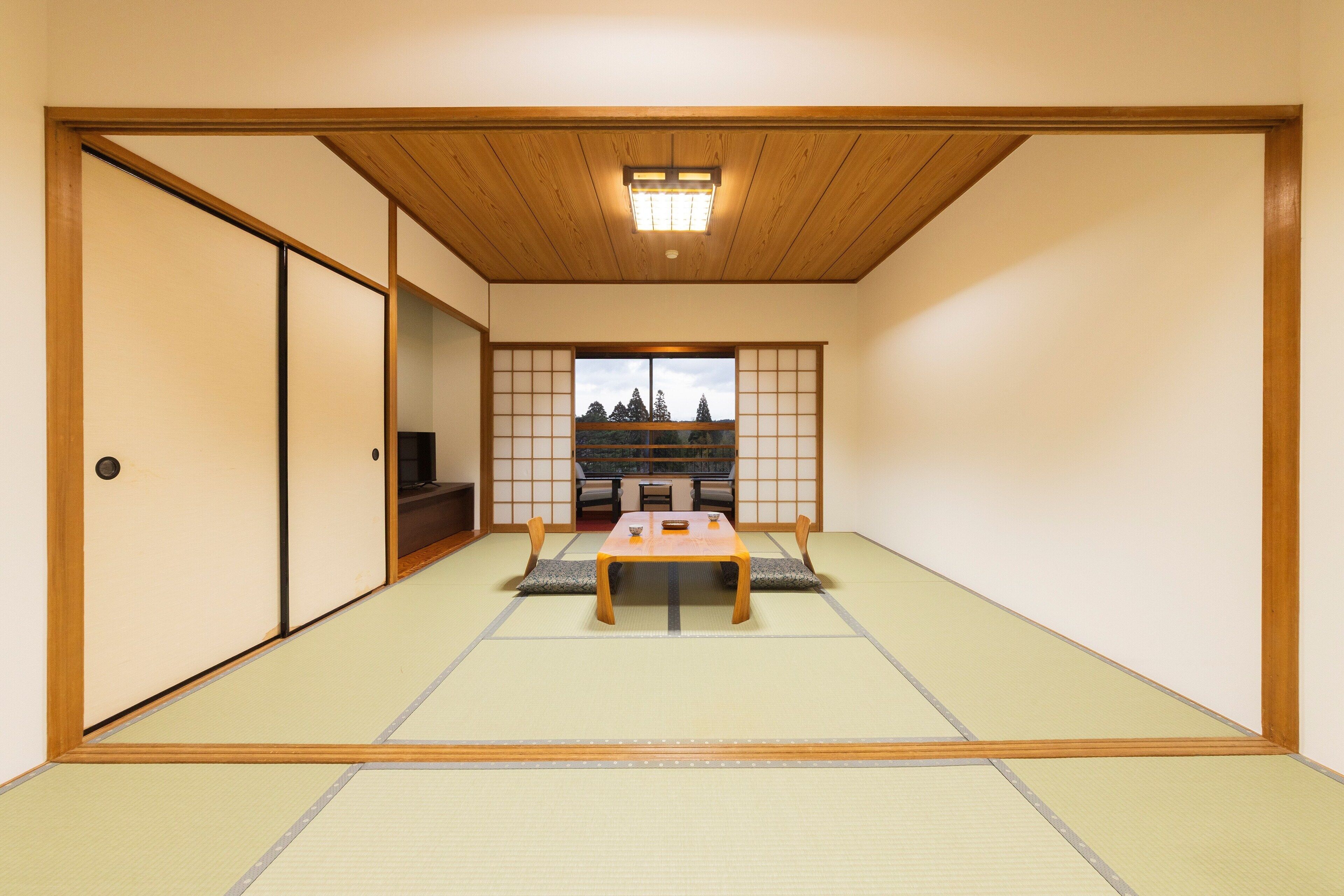 A traditional Japanese room with tatami flooring, a low wooden table, and sliding doors.