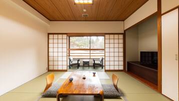 A traditional Japanese room with tatami flooring, a wooden table, and a sliding door.