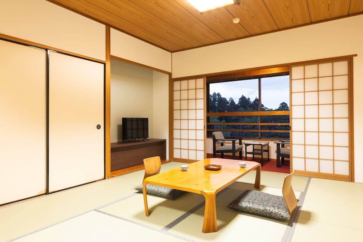 Une pièce de style japonais traditionnel, avec un sol recouvert de tatamis, une basse table en bois et des portes coulissantes.