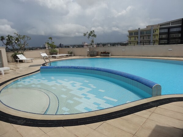 A rooftop swimming pool with tiled edges, lounge chairs, and potted plants. - Exclusive 2  room ( 3 Beds) apartment  in City  Centre (Colombo)