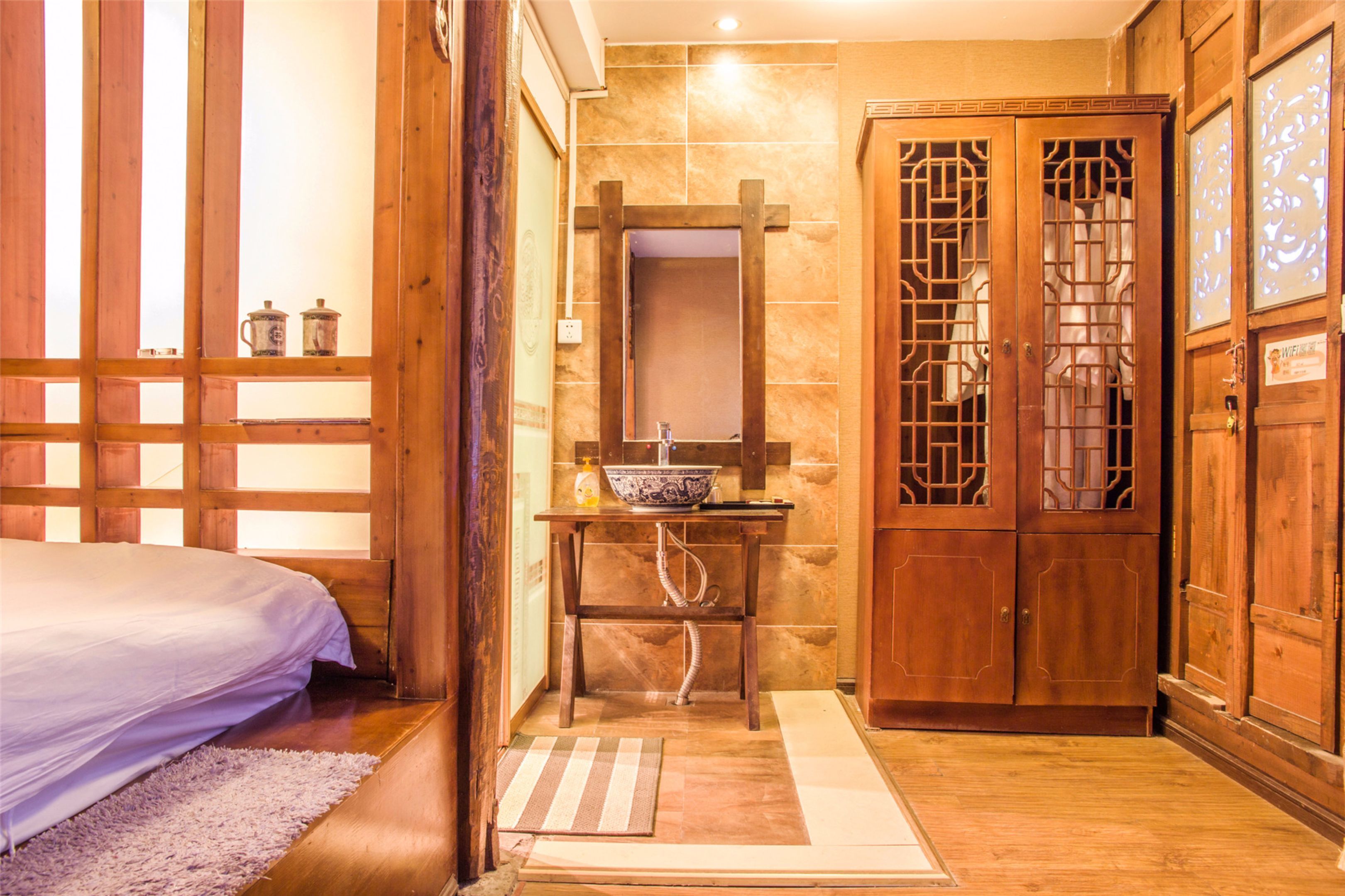 A traditional Japanese-style room with a bed, a wooden cabinet with glass doors, and a sink with a bowl.