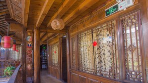 Un couloir traditionnel en bois, orné de motifs complexes et doté d’un plancher en bois.