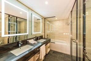 Een moderne badkamer met twee wastafels, een grote spiegel en een douchecabine van glas.