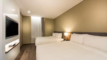 Une chambre d’hôtel avec deux lits, une télévision et une fenêtre avec des rideaux.