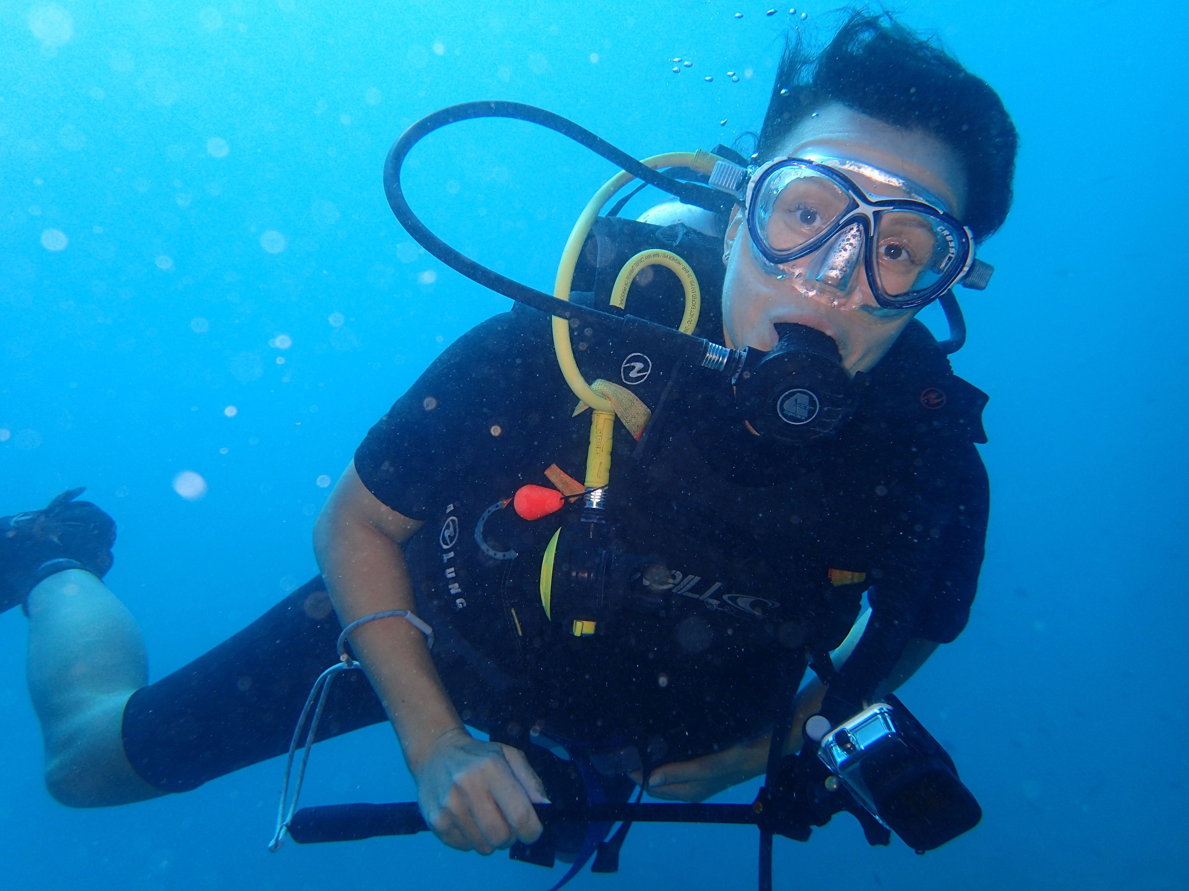 A diver underwater with a scuba mask and breathing apparatus.