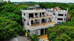 A multi-story building with balconies, surrounded by lush greenery. - Aquarius Terraces Boutique Resort (Boracay Island)