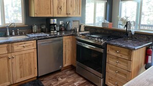 A kitchen with wooden cabinets, stainless steel appliances, and a window providing natural light.