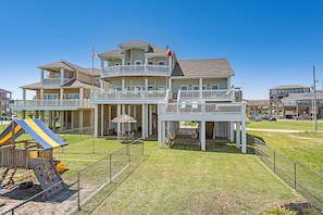 A two-story building with a balcony and a play area with a slide.
