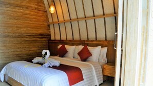 Habitación con paneles de madera, una cama, almohadas y una toalla.