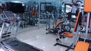 A gym with various exercise equipment, including treadmills and weight machines. - Résidence Ethan (Abidjan)