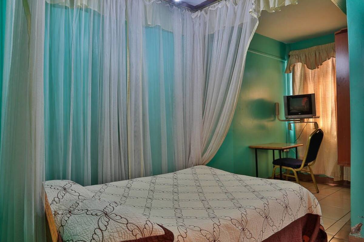 A room with a bed, a television, and a chair.