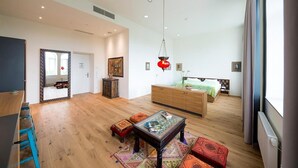 A spacious living room with a wooden floor, a sofa, a coffee table, and a large mirror. - Gabrium (Maria Enzersdorf)