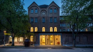 A historic building with a clock tower, large windows, and a well-lit entrance. - Gabrium (Maria Enzersdorf)