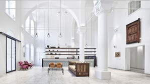 A spacious interior with high ceilings, arched windows, and a central seating area with a sofa and chairs. - Gabrium (Maria Enzersdorf)