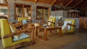 A rustic interior with stone walls, wooden furniture, and a stone fireplace.