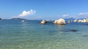 On peut admirer une mer calme et dégagée, parsemée de gros rochers blancs qui émergent de l’eau.