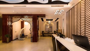 Un espace d’accueil moderne comprenant un comptoir, un ordinateur et un coin salon.