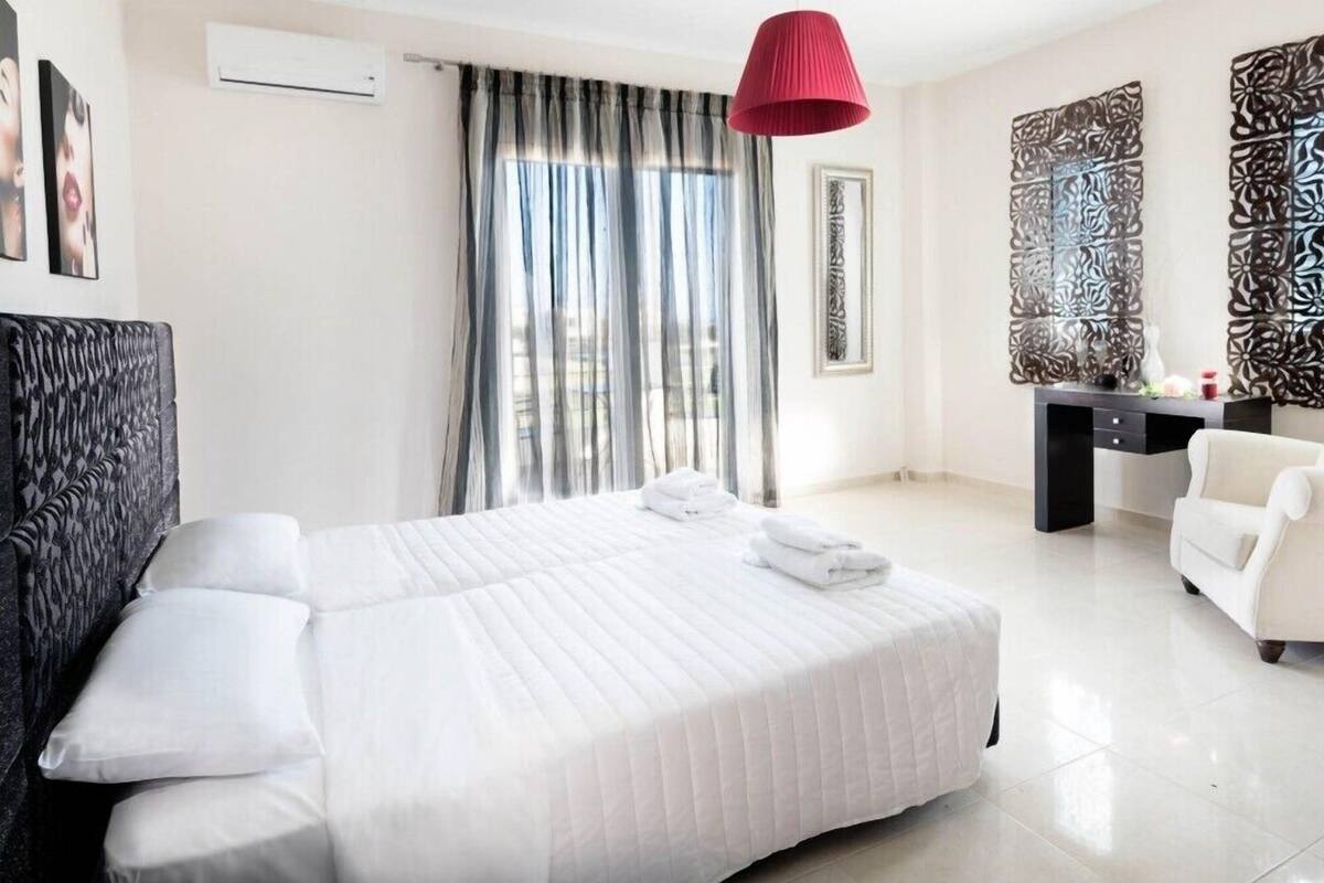 Una habitación de hotel con una cama grande, un escritorio, una silla y un panel decorativo en la pared.