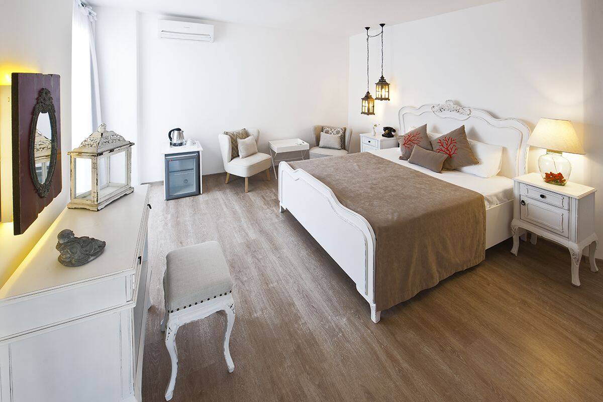 A bedroom with a large bed, bedside tables, a chair, a dresser, and a mirror.