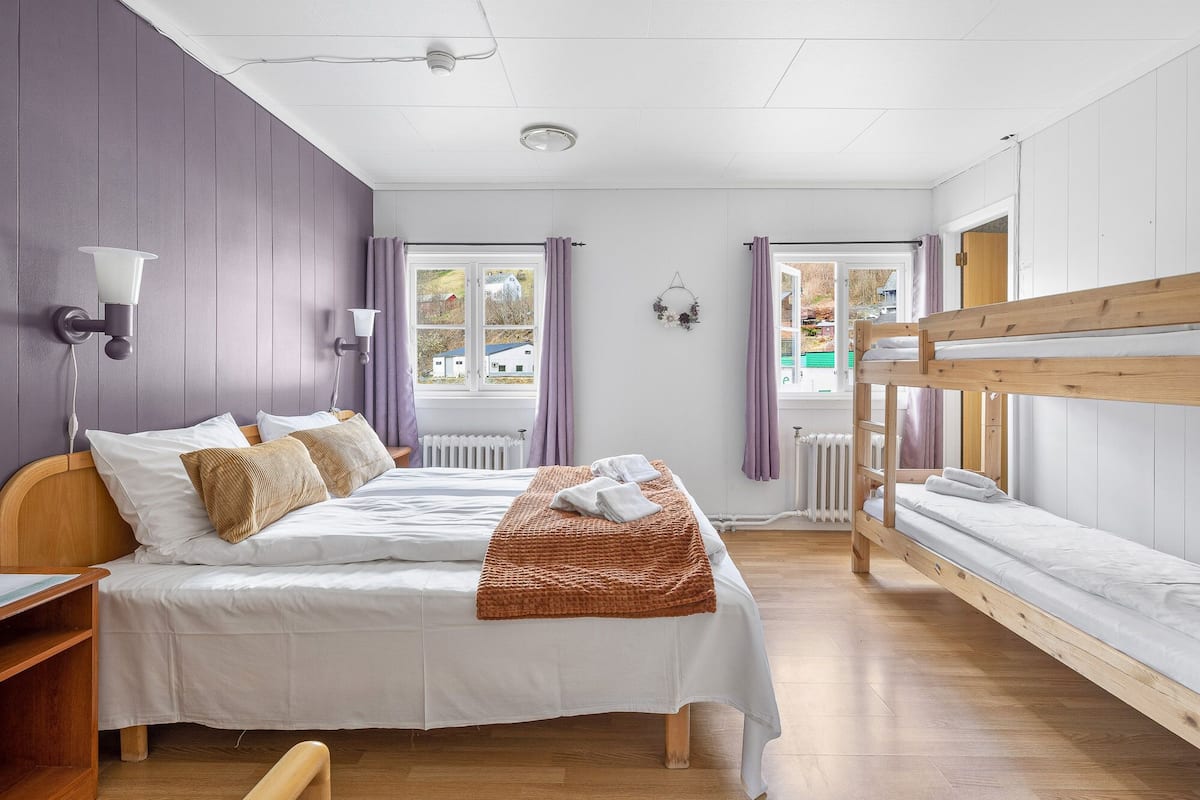A bedroom with a bunk bed, a single bed, and a desk.