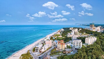 A coastal town with a beach, residential buildings, and a construction site.