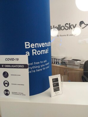 Un pilier bleu sur lequel on peut lire « Bienvenue à Rome ! » ainsi que les consignes de sécurité liées à la COVID-19.
