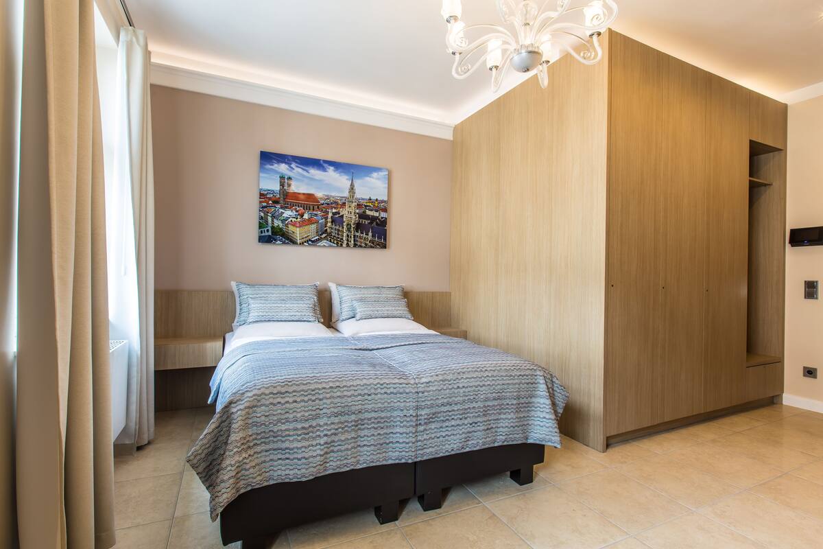 A modern bedroom with a bed, a bench, and a wardrobe.