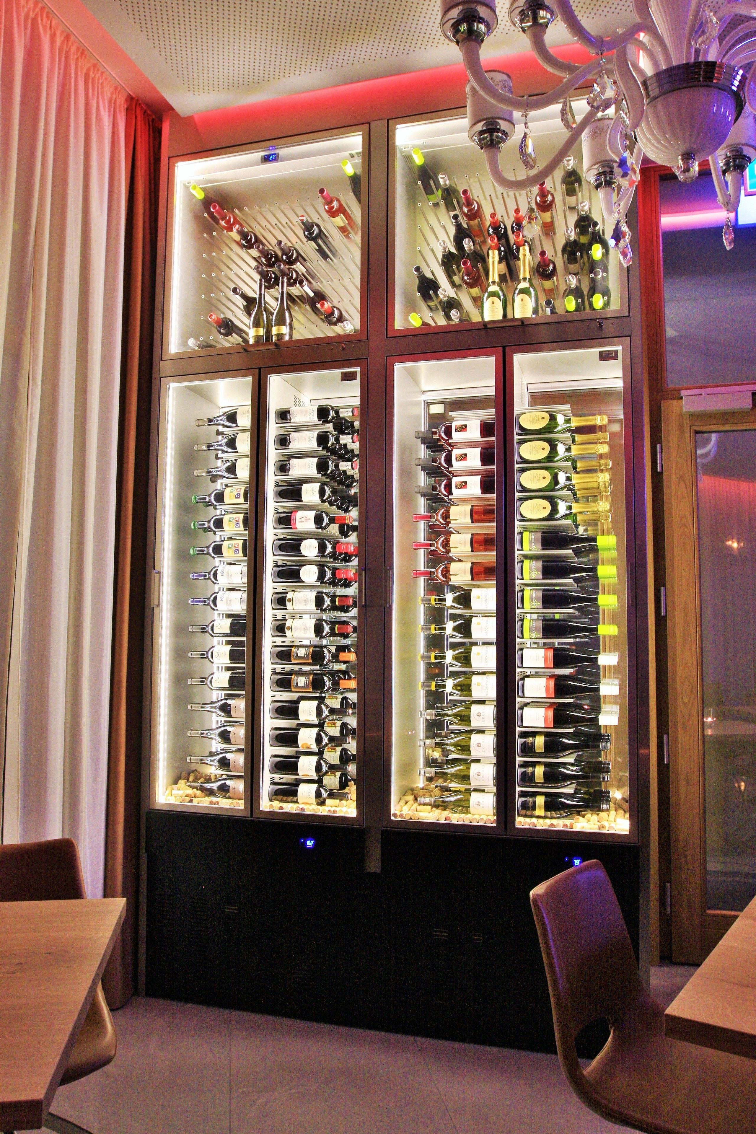 A wine refrigerator with multiple shelves of wine bottles.