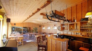 A wooden interior with a bar area, tables, and chairs. - Ulvik Camping (Ulvik)