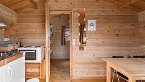 A compact wooden cabin with a kitchenette, a dining area, and a shower. - Ulvik Camping (Ulvik)