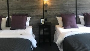 A hotel room with two beds, a nightstand with a lamp, and a clock. - Hamburg Room (Hamburg)