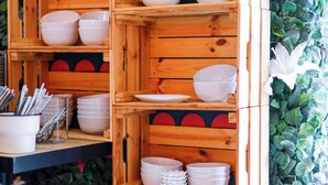 Un expositor de madera con varias estanterías que sostienen cuencos y platos blancos.