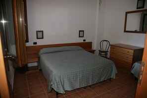 A bedroom with a bed, a chair, a dresser, and a mirror. - Villaggio Borgo Marino (Zambrone)