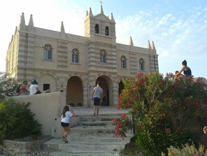 A historic building with a central tower, arched doorways, and a staircase leading to the entrance. - Villaggio Borgo Marino (Zambrone)