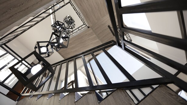 A modern interior with exposed structural beams and geometric light fixtures. - Keremet Hotel (Almaty)