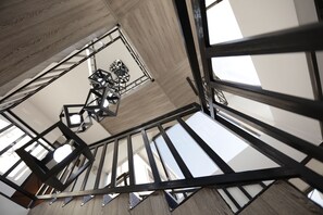 A modern interior with exposed structural beams and geometric light fixtures. - Keremet Hotel (Almaty)