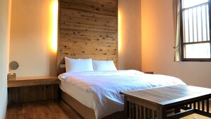 A wooden-paneled bedroom with a bed, bedside table, and a window with curtains. - Village B&B (Lugu)