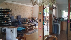 Amplia sala de estar con mesa de comedor, sofá y estante para vinos.