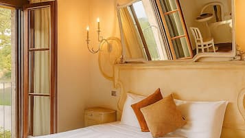 Une chambre à coucher avec un grand lit, un miroir, une table de chevet et une fenêtre avec des rideaux.